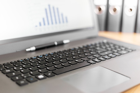 Laptop computer with graph on screenの写真素材