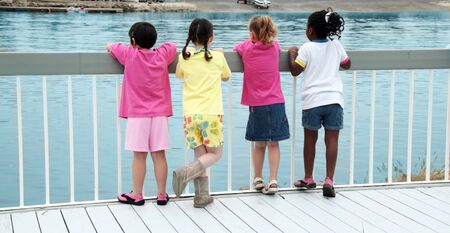 Girls on a Dock Watching Boats Pass Byの写真素材