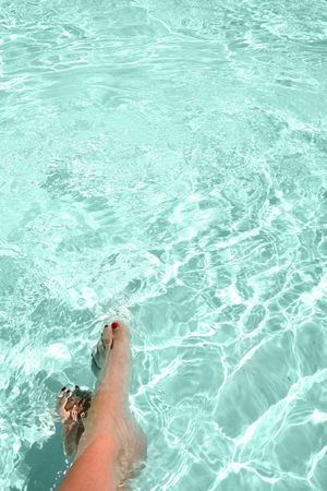 Women's feet in a bright poolの写真素材