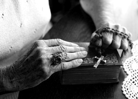 Elderly Woman's Hands Holding Her Bible and Rosaryの写真素材