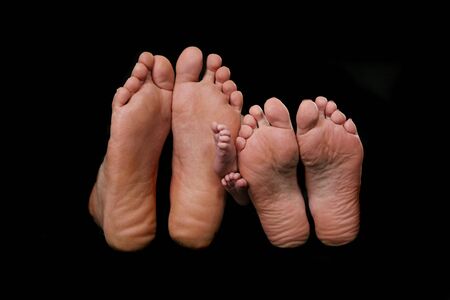 Family of Three's Bare Feet: Note the Newborn's Tiny Feet in the Middleの写真素材