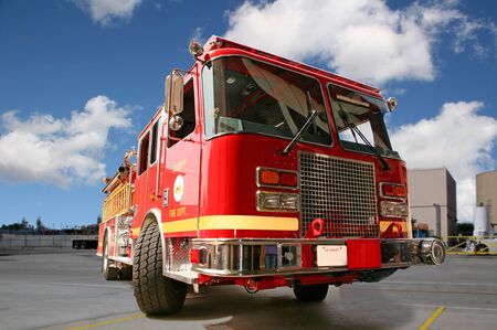 Fire engine on pavement with clouds in the background