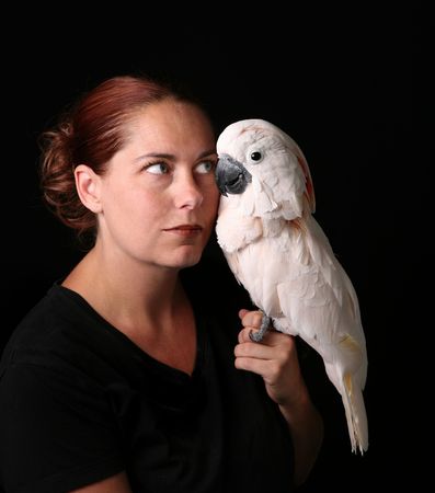 Caucasian Woman Holding Her Pet Moluccan Cockatoo on Blackの写真素材