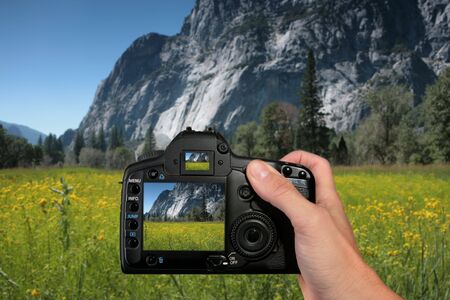 Tourist Taking a Photograph of Mountains in Yosemite National Parkの写真素材