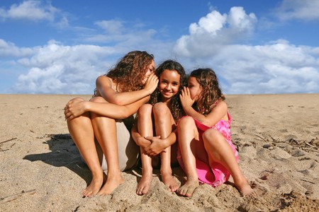 Sisters at the Beach Whispering Funny Secrets to Eachotherの写真素材