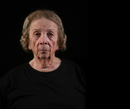 Senior Citizen Caucasian Woman in Deep Thought on Black Backgroundの写真素材