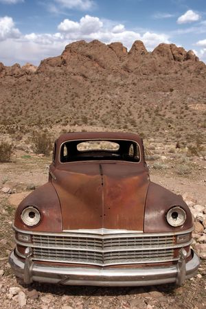 Old Rusted Out Car in the Desert Landscapeの写真素材