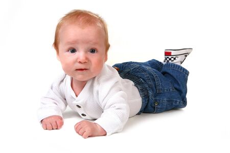 Surprised Baby Boy on His Tummy Wearing Jeansの写真素材