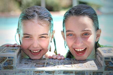 Smiling Young Children in a Swimming Pool During Summerの写真素材