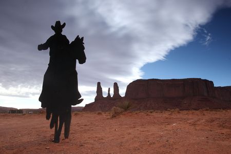 Cowboy on a Horse Silhouette With Three Sisters Monument in the Backgroundの写真素材