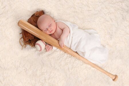 Swaddled Sleeping Baby Boy With a Baseball Bat and Ballの写真素材