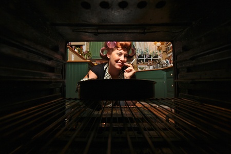 Housewife Smoking and Cooking Dinner in a Vintage Oven