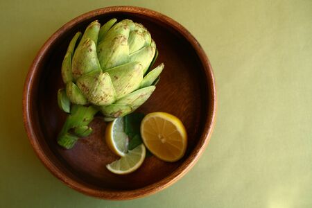 Fresh Artichoke in Wooden Bowl With Lemonsの写真素材