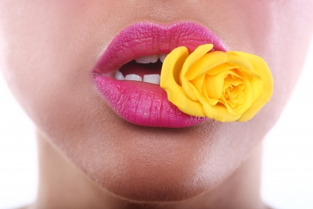 Beautiful Woman With Sensual Lips Holding Flower in Mouthの写真素材