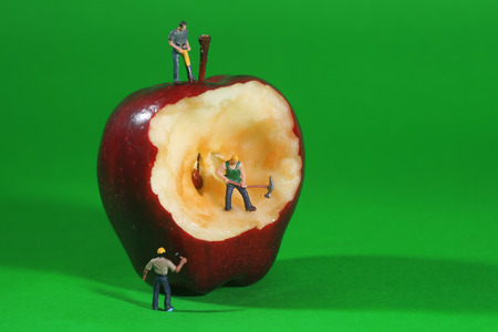 Miniature Construction Workers in Conceptual Imagery With an Appleの写真素材