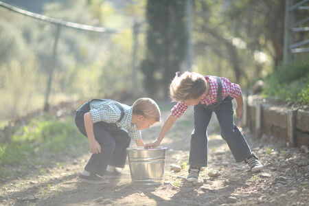 Young Kids Working on the Farm  With a Pailの写真素材