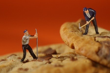Miniature Plastic People Working on Chocolate Chip Cookiesの写真素材