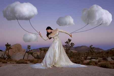 Creative Concept of Girl Attached to Clouds Representing Fantasyの写真素材