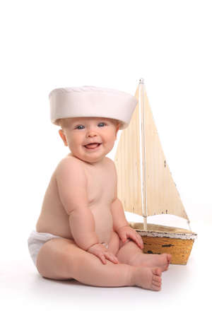 Happy Baby Toddler Sitting up Wearing Sailor Hat on White Backgroundの写真素材