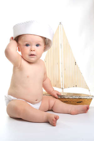 Happy Baby Toddler Sitting up Wearing Sailor Hat on White Backgroundの写真素材