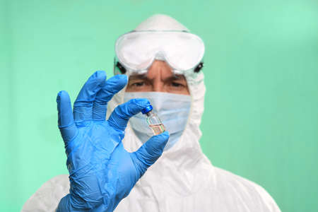 Virus Lab Technician Doctor Handling a Vial of Vaccineの写真素材