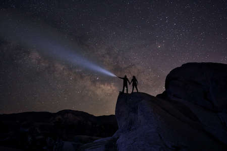 Happy Couple Silhouette Under the Stars at Nightの写真素材