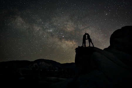 Happy Couple Silhouette Under the Stars at Nightの写真素材