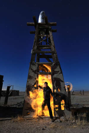 Man Light Painted With Fire in Industrial Settingの写真素材