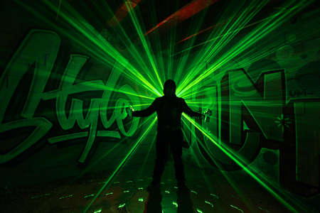 Young Man Light Painted With Spray Cans While Painting Graffitiの写真素材