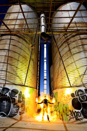 Man Light Painted With Fire in Industrial Settingの写真素材