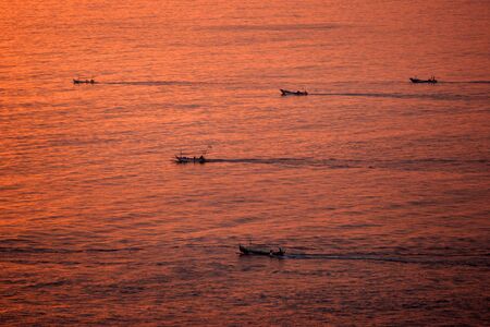 Fiherman boat during sunset landscape scenery in Uluwatu Bali Indonesia の写真素材