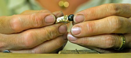Uppsala, Sweden - August 27, 2013  The goldsmith at work, a closeup when she fix the stone on the ringのeditorial素材