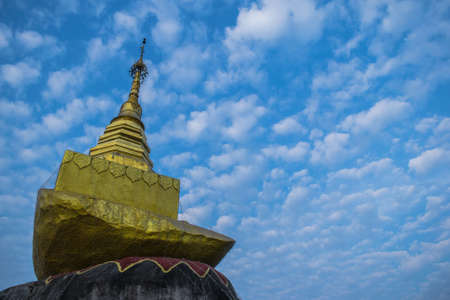 golden pagoda on the rock and cloudy blue skyの写真素材