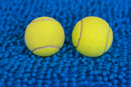 Tennis ball put on the blue wool doormatの写真素材