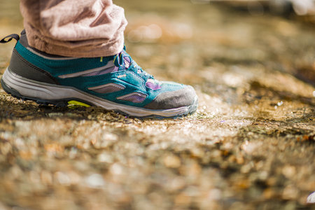 Close-up view of a hiking shoe stepping in shallow waterの写真素材