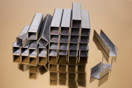 A pile of staples on gold.の写真素材