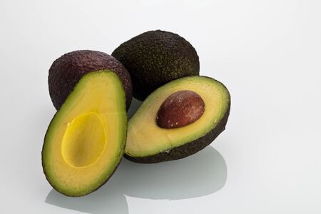 Avocados one cut in half whit the pip on isolated background.