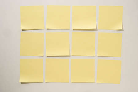 Yellow Sticky Notes Lined up on a White Backgroundの写真素材