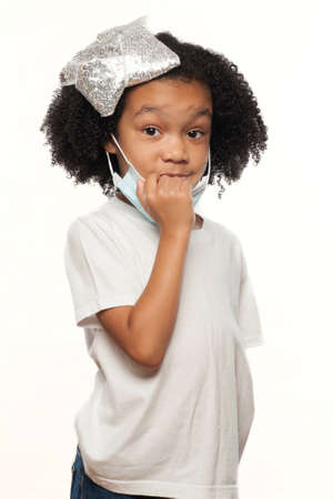 Cute Young Expressive African American Girl Wearing a Surgical Mask on a White Backgroundの写真素材