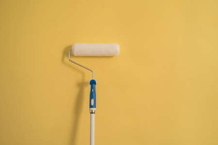 White Paint Roller on a Yellow Wallの写真素材