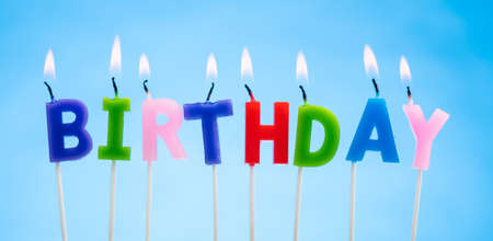 Colorful Candles on a  Blue Background that Spell Birthdayの写真素材