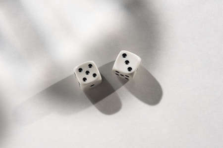 White Dice on a White Background with Harsh Shadows