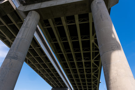 View Underneath a Large Bridge Highway on a Sunny Day with Blue Skyの写真素材