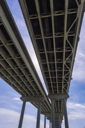 View Underneath a Large Bridge Highway on a Sunny Day with Blue Skyの写真素材