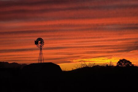 Lone Windmill silohuetted in an Arizona sunsetの写真素材