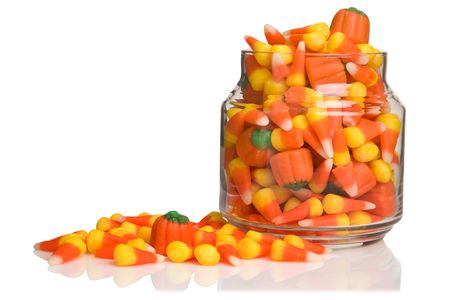 Halloween candy-corn and pumpkins overflowing the jar