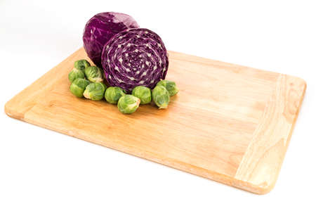 red cabbage and brussel sprouts on wood cutting board angle viewの写真素材