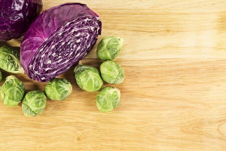 red cabbage and brussel sprouts on wood cutting board over top view