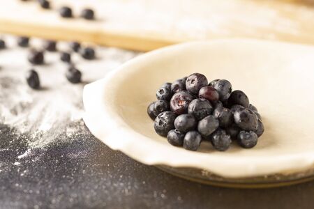 a fresh blueberry pie in the process of being baked.の写真素材