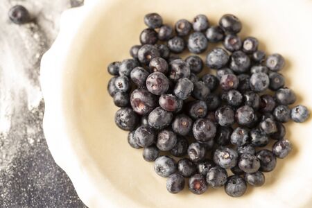 a fresh blueberry pie in the process of being baked.の写真素材